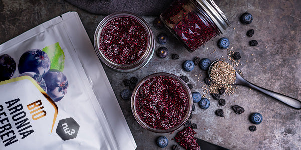 nu3 Bacche di aronia giacciono accanto a marmellata e frutti di bosco freschi 