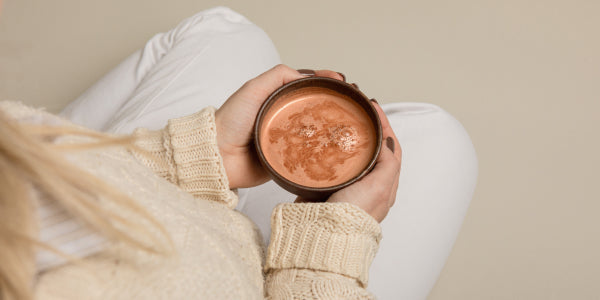 Donna con in mano una tazza di cacao proteico